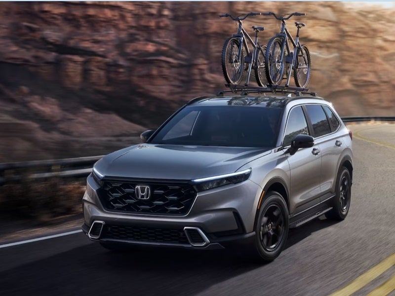 image of Honda SUV with a bike rack and bikes on top