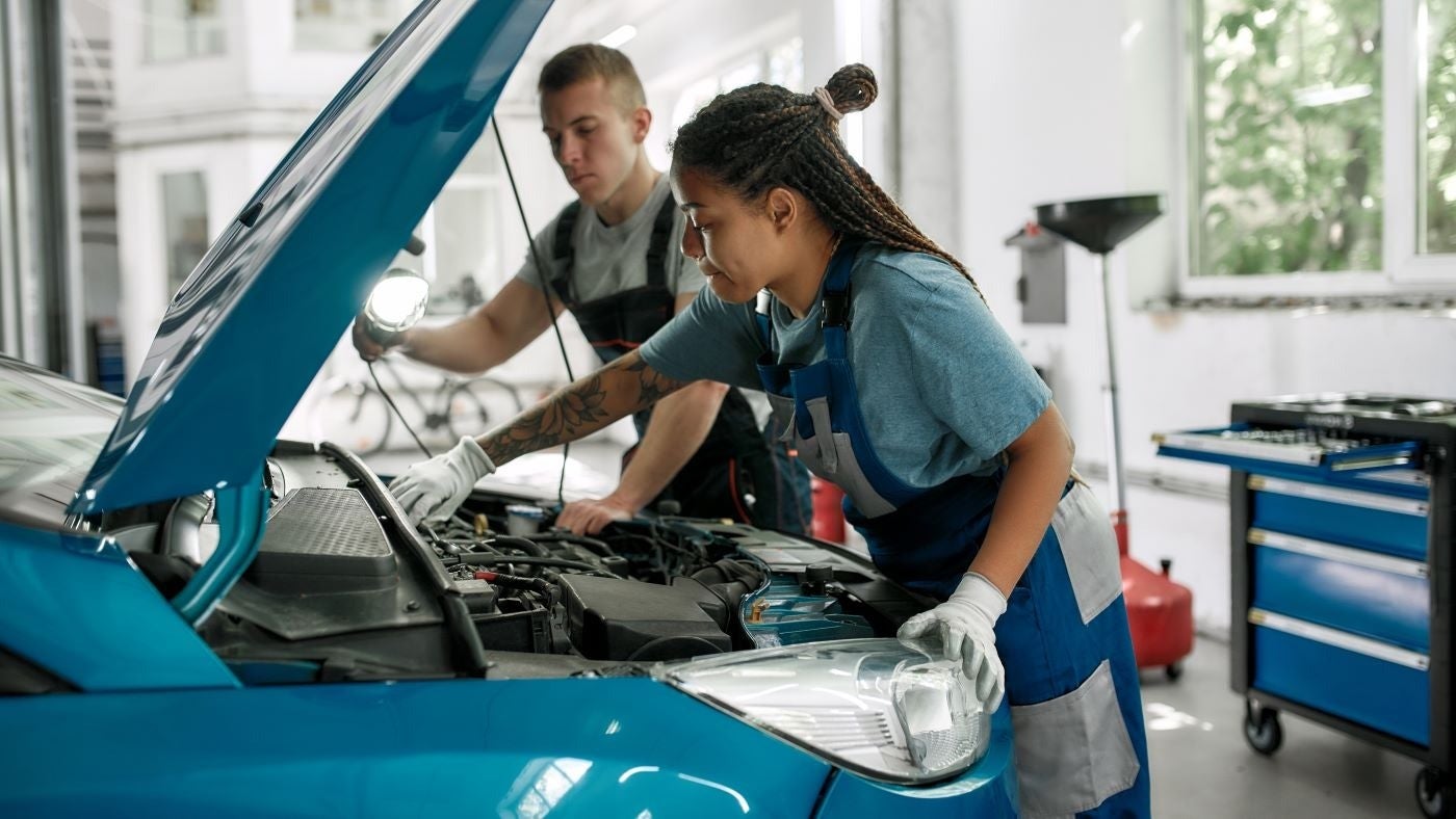 image of 2 mechanics working on a car